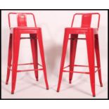 2 Industrial red metal tolix bar stools. Pressed metal construction with pierced seats.