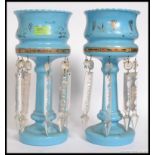 A Victorian pair of blue glass table lustres.