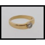 An 18ct gold and diamond ring with a single round cut diamond of approximately .