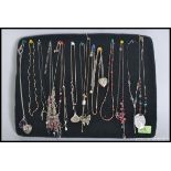 A collection of silver and white metal ladies necklaces with pendants.