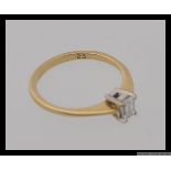 An 18ct 750 gold ring set with a single emerald cut diamond of .25pts. Hallmarked for Birmingham.