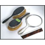 A decorative hallmarked silver and tortoiseshell part vanity set - to include mirror,