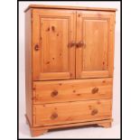 A contemporary country pine tallboy cabinet chest of drawers.