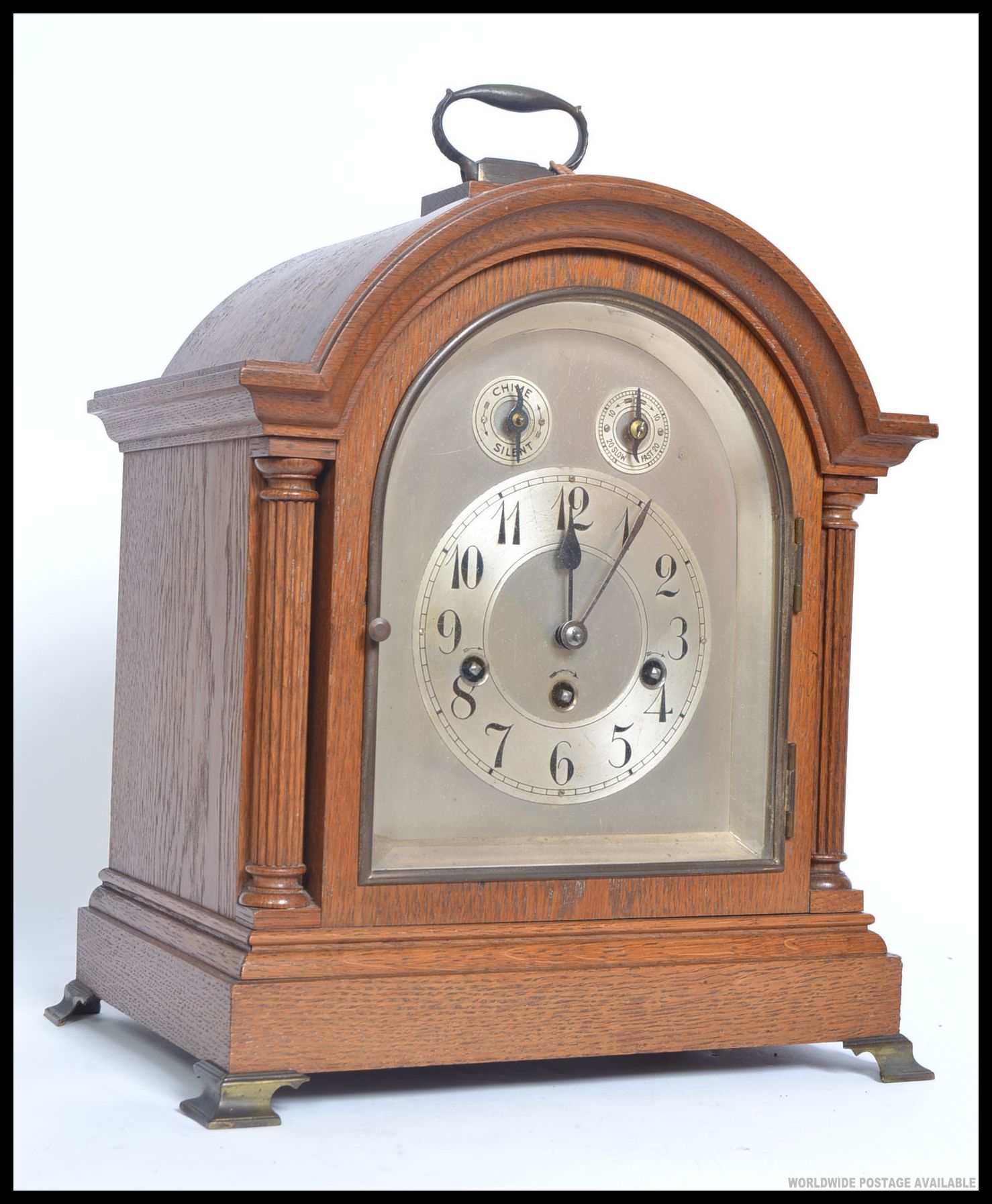 An 20th oak cased mantle clock, having a silvered face with two subsidiary dials,