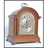 An 20th oak cased mantle clock, having a silvered face with two subsidiary dials,