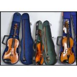 A collection of violins to include student violins,