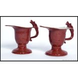 A pair of Chinese monochrome red dragon handled creamers - pourers.