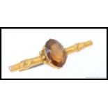 A 9ct gold and topaz set ladies bar brooch with pin to verso, central oval cut stone.