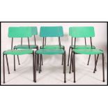 A stack of 1970's retro green plastic and tubular metal Industrial dining chairs.