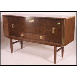 A retro  1960's melamine faux wood sideboard raised on tapered legs with inset bank of drawers and