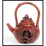 A 20th century terracotta Contemplation Yixing Teapot having a recess containing a Buddha inside,