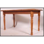 A contemporary pine dining table raised on turned legs ( that remove ) with a fitted frieze and