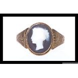 A 19th century 9ct gold cameo set ring with chased foliate decoration to shoulders.  Size Q.