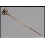 A 14ct gold and amethyst set ladies stick pin. The central stone being claw mounted.