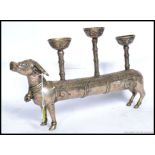 A 20th century white metal Indian elongated cow candlestick holder.