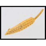 A vintage yellow metal brooch stylized in the shape of an ear of wheat / corn. Length 6.5cms.