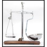 An early 20th century chrome and wooden plinth mounted pair of snuff scales by Avery.