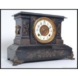 An Ansonia black metal mantel clock striking on a gong having decorative facia.