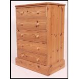 A good quality contemporary pine chest of drawers being raised on a plinth base with an upright