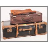 A vintage mid century leather strapped suitcase along with a leather example and vintage leather