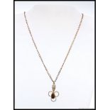 A 9ct gold necklace with gold and agate stone set pendant of filigree form. Stamped 9ct.