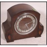 A 1940's oak cased mantel clock with silvered dial striking on a chime.