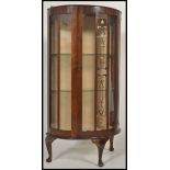 An early 20th century demi loon display cabinet, having art nouveau design to the glass,
