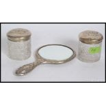 A pair of matching Edwardian dressing table cut glass silver hallmarked lidded pots with matching