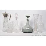 A collection of cut glass decanters to include one by Dartington along with a silver plated claret