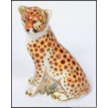 A Royal Crown Derby paperweight Cheetah Cub with gold stopper.