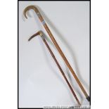 A silver collared horn cane riding crop along with a silver collared horn handled walking stick