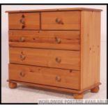 An antique style pine chest of drawers having short and deep drawer configuration.