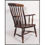 A Victorian 19th century elm and beech Windsor high back elbow chair united by turned stretchers