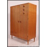 A 1960's retro upright blond oak pedestal tallboy chest of drawers by Meredew.