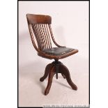 A good 1920's oak Industrial office swivel chair raised on quadruped base with fan back rest and