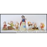 A collection of Snow White & 7 Dwarves figurines to include Snow White, Dopey with Candlelight,