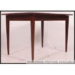 A retro 1970's teak wood dining table raised on extending frieze frame with central additional leaf.