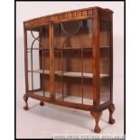 A 1930's Art Deco walnut bow front china display cabinet raised on cabriole legs with ball and claw