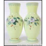 A pair of Victorian green glass handpainted vases with decorative foliate designs H29cm