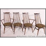 A set of 4 Ercol beech and elm wood dining chairs having panel seats with arched back rests,