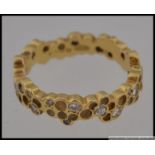 A hallmarked 18ct gold honeycomb diamond band ring set with approx 30pts of graduated diamonds in a