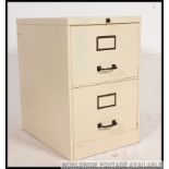 A 20th century painted metal industrial twin filing cabinet with recessed handles and paper