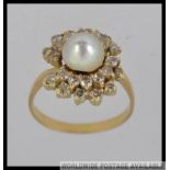 An 18ct gold diamond and pearl ladies cluster ring with central pearl. The diamonds approx 1.