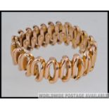 A designer yellow metal articulated expanding bracelet (tests for 9ct) with expanding links marked
