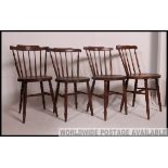 A set of 4 Victorian beech and elm windsor dining chairs raised on turned legs with circular seats