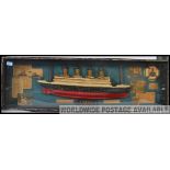 A Framed and glazed large display case with half model hull of the Titanic together with ephemera