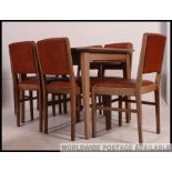 An original Gordon Russell walnut extending dining room table together with a set 5 dining chairs
