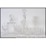 Two 20th century cut glass decanters with stoppers along with a set of four matching cut glass