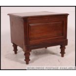 A late Victorian mahogany commode raised on turned legs with hinged top and ceramic lined interior