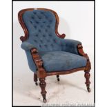 A Victorian mahogany spoon back armchair of large form with blue button backed upholstery to the